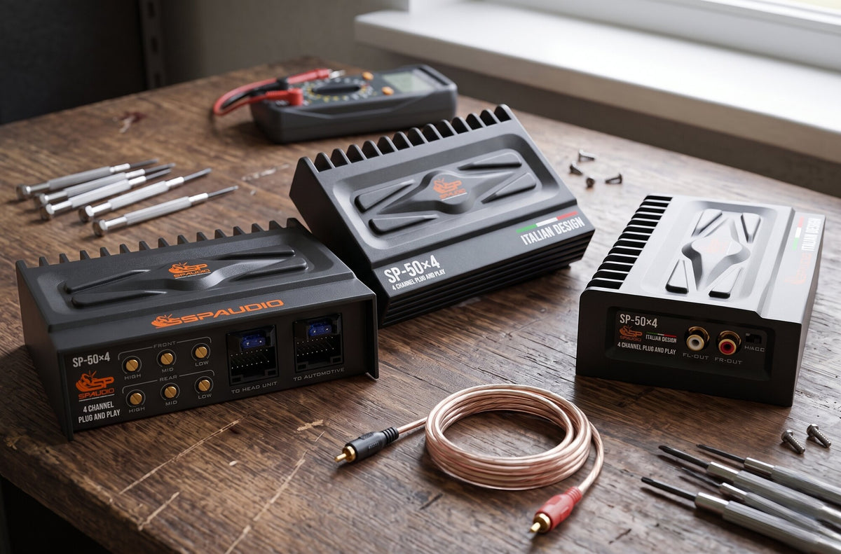 Three SP-50x4 4-channel plug and play amplifiers on an installer's workbench with multimeter and RCA cable